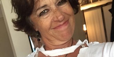 Smiling woman with short dark hair in a white top.