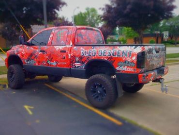 Customized off-road truck with vibrant red and black design.