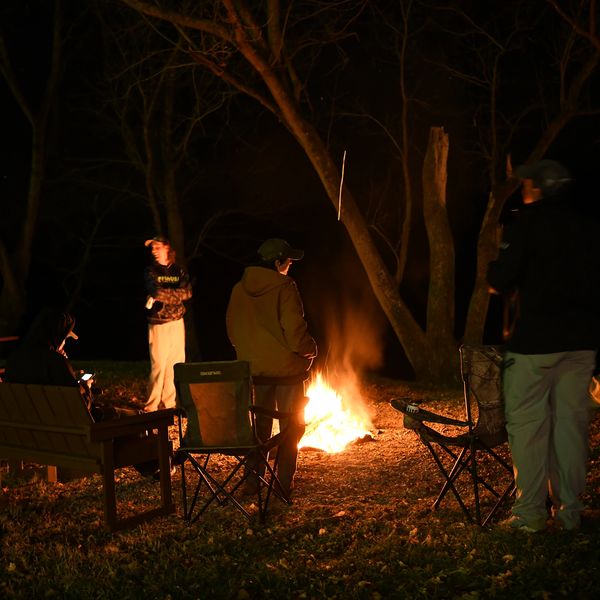 Corporate outing team building enjoying a fire and beer