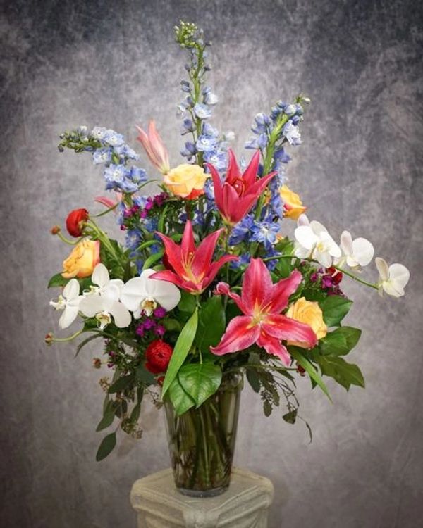 Tall and airy arrangement with mixed colors and flowers.