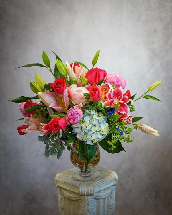 Mix color floral arrangement with roses, hydrangeas, lilies, peonies with some filler greens.