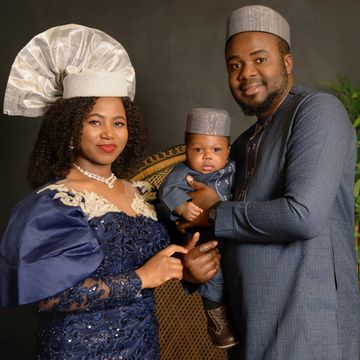 A family dressed in elegant traditional attire poses for a portrait.
