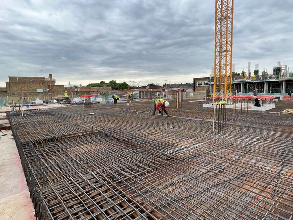 Construction workers making steel rebar at construction site
