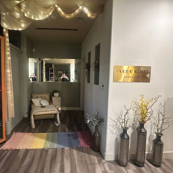 Cozy, softly lit relaxation nook with a lounge chair and decorative vases.