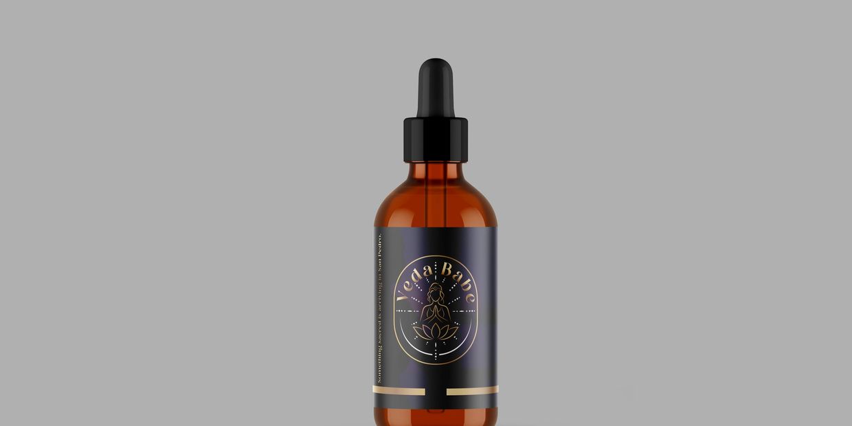 Amber dropper bottle labeled Veda Babe with a serene logo on a gray background.