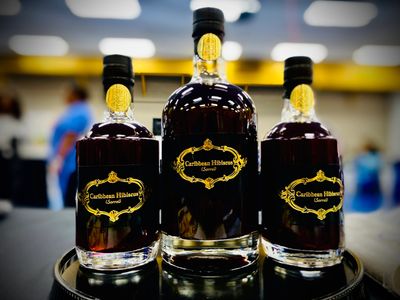 Three elegant bottles of Caribbean Hibiscus liqueur on display.