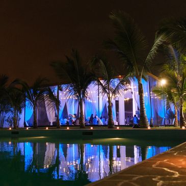 piscina con un toldo en colo azul y palmeras