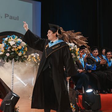 graduado sonriendo señalando arriba