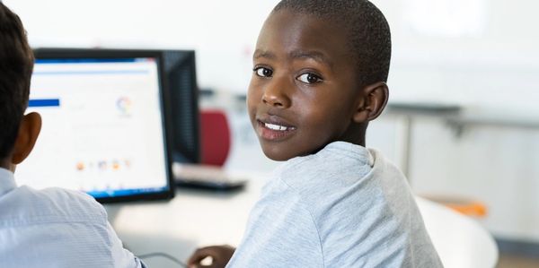 a smiling little boy using a computer