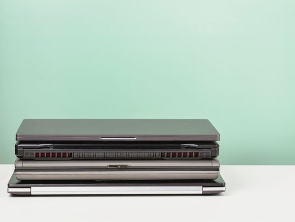 a stack of laptops on a white table