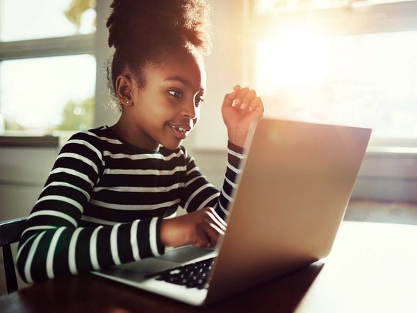 a little african girl using a laptop