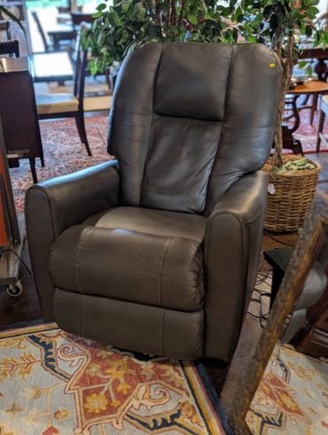 Brown leather recliner chair in a cozy room setting.