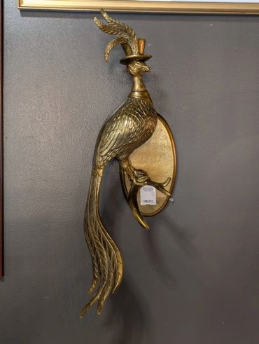 Ornate brass bird wall sconce with long tail feathers and a top hat.