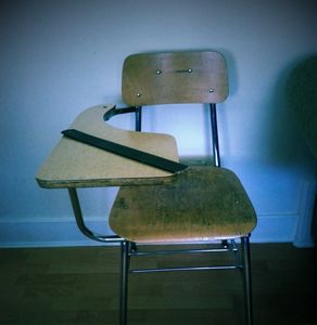 A school desk with a strap on it 