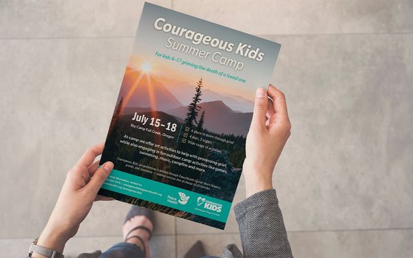 Person holding a flyer for Courageous Kids Summer Camp for grieving children, July 15-18.