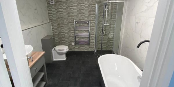 Modern bathroom with bathtub, shower, and toilet.