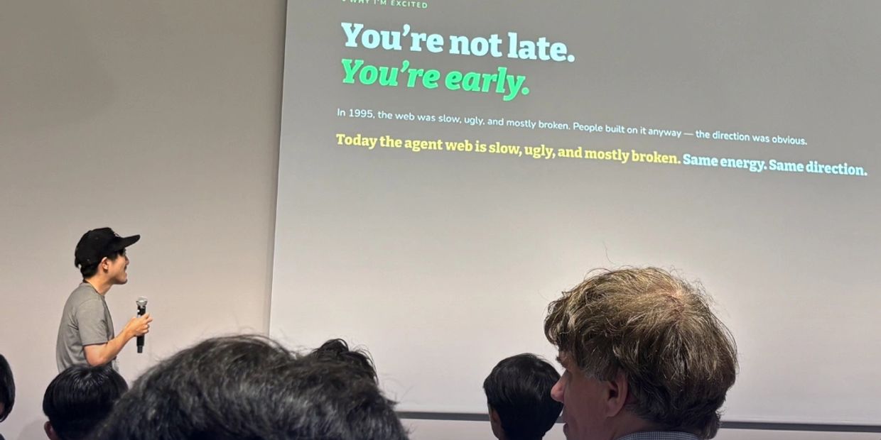A person giving a presentation with text on the screen reading "You're not late. You're early."