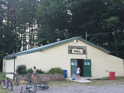 Community gathering at Centennial Hall surrounded by trees and bicycles.