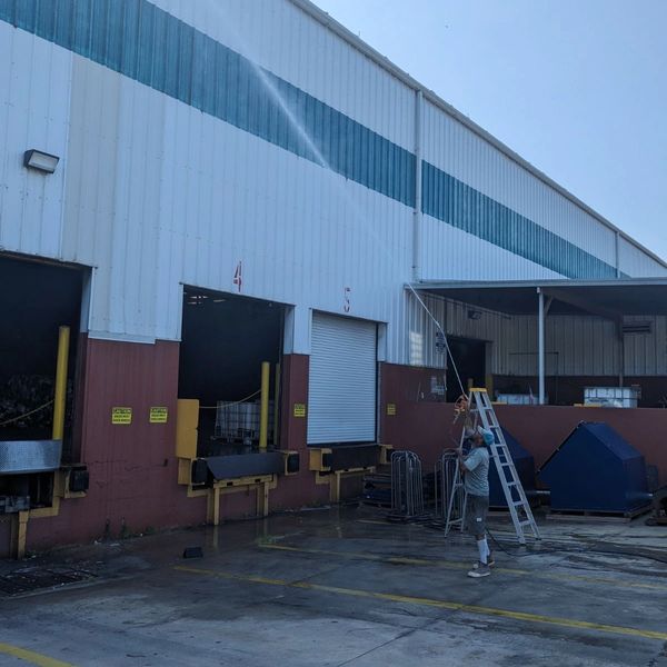 Pressure washing a ware house building