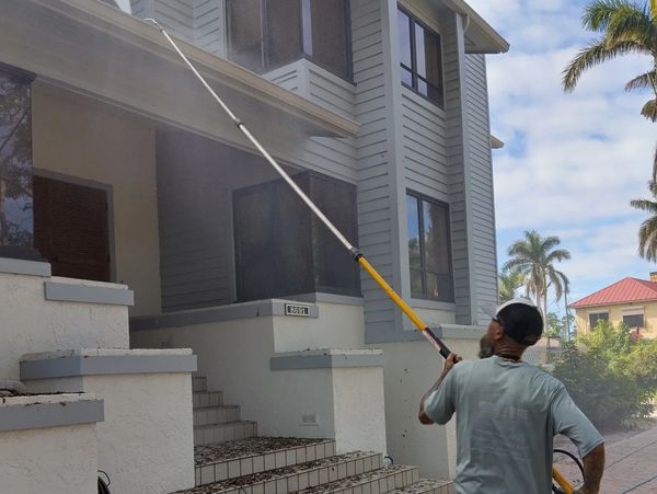 cleaning gutters on a house with a l pressure washing  pole made for gutter cleaning from the ground