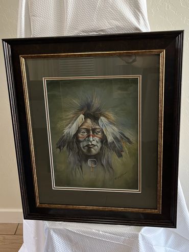 Native American face with white/grey feathers on his hair