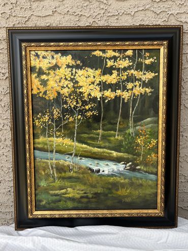 Green grass, yellow leaves trees with creek in the center