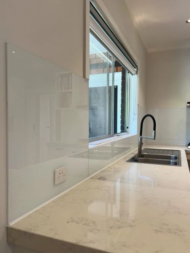 Modern kitchen countertop with a sleek faucet and window.