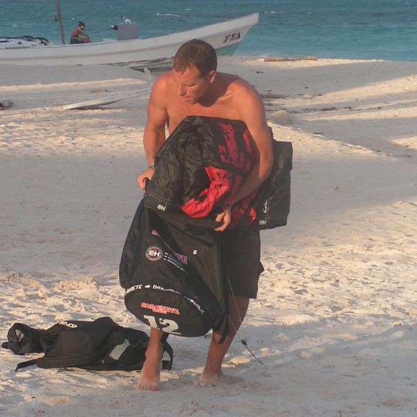 Stuffing a kitesurfing kite into its bag.