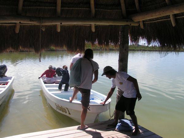 Getting into an open boat at a tropical dock.