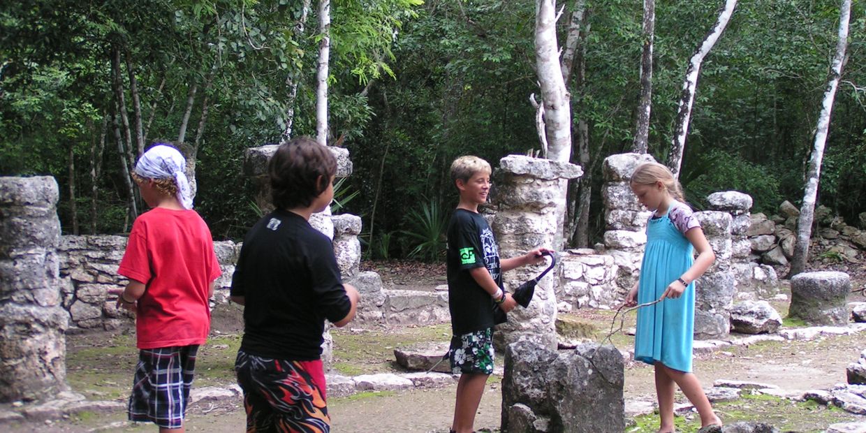 Kids exploring ancient Maya ruins.