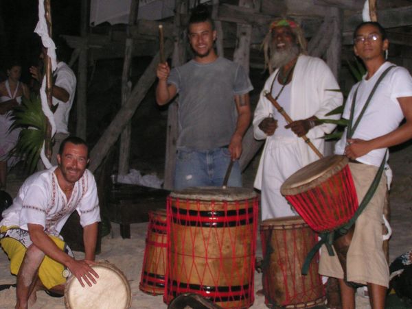 Folk music drummers on a beach at night.