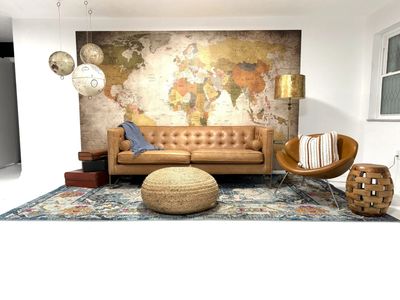 Living room with a tufted leather sofa, world map wall art, and mid-century modern accents.