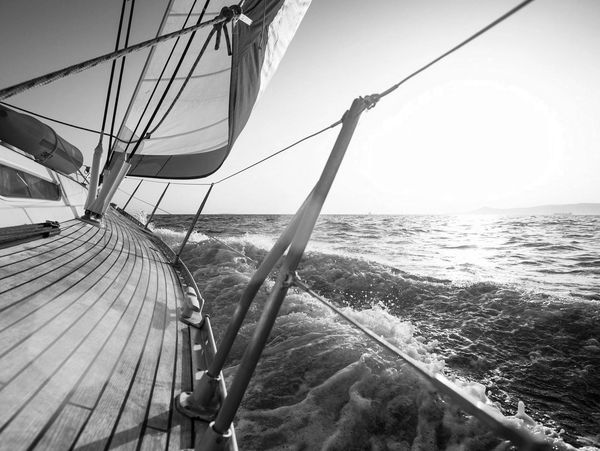 A sailboat moving through the sea, viewed along its deck.