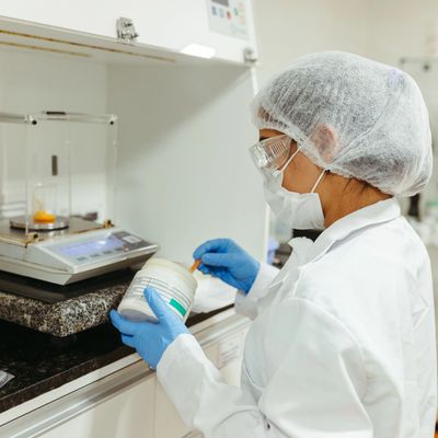 Científica manipulando un frasco en un laboratorio.