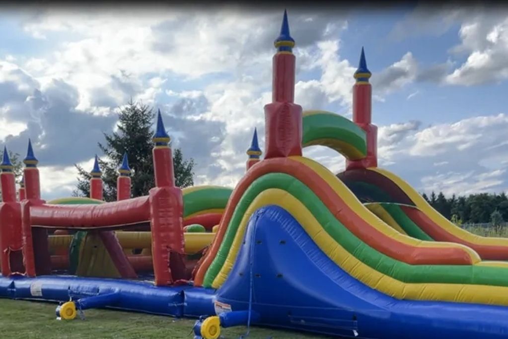Colorful inflatable obstacle course under a cloudy sky.