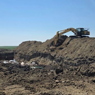 Excavator digging a trench in Linden Alberta