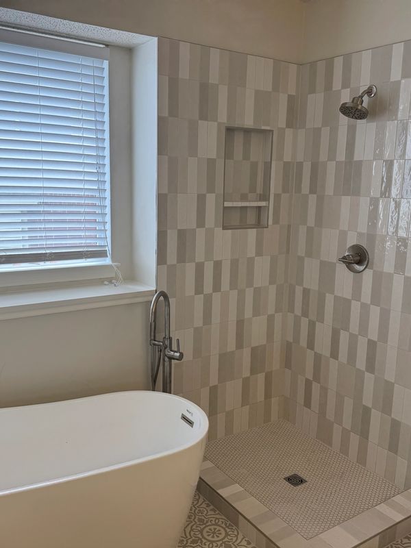 Modern bathroom with a freestanding tub and tiled shower.