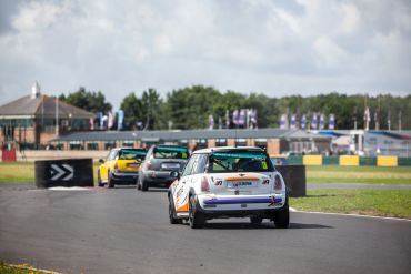 Mini Coopers racing on a track.
