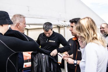 People gathered around in matching black jackets.