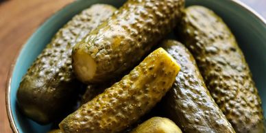 A bowl of whole pickles ready to eat.