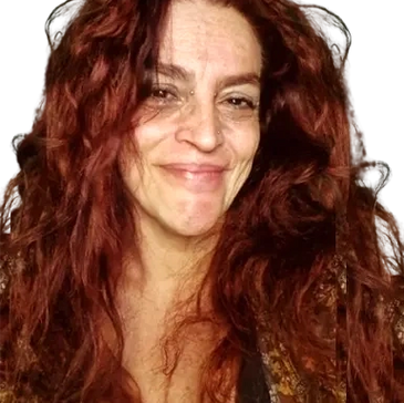 Smiling woman with long, curly red hair.
