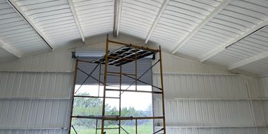 Spray foam insulation applied to a metal building.  This installation improves energy efficiency, se