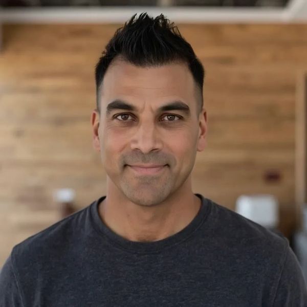 Man in a dark shirt smiling.