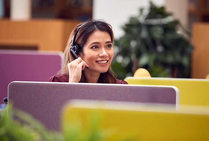 Smiling customer service representative wearing a headset.