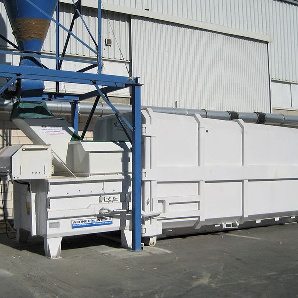 Large industrial white machine with metal framework outdoors.