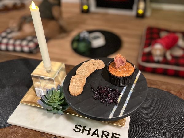 Luna and Escobar lounge while the star of the show—a bacon cupcake, cookie, and blueberries—shines.