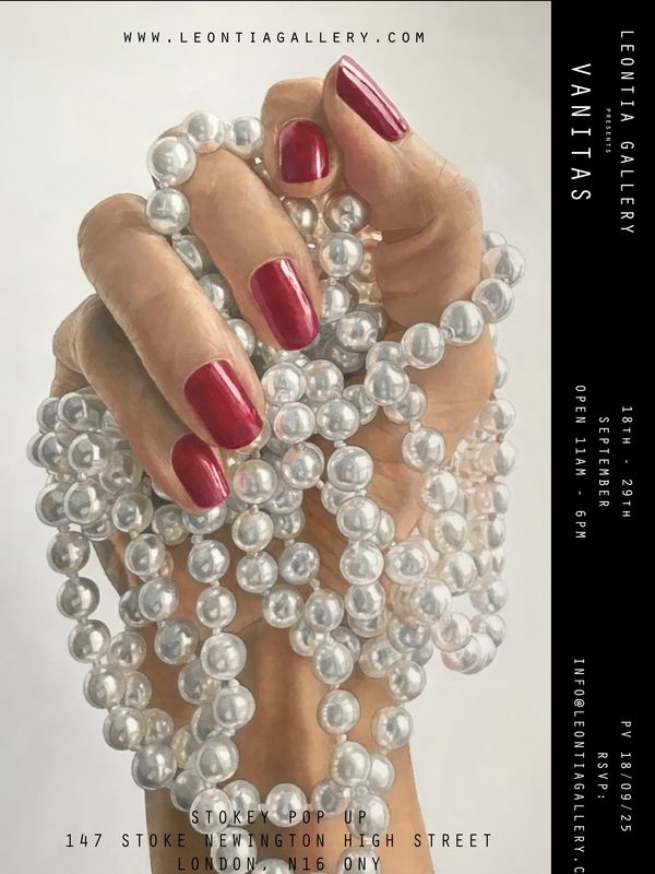 Hand with red nails holding pearl necklaces.