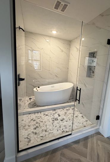 Modern bathroom with a freestanding tub and glass enclosure.