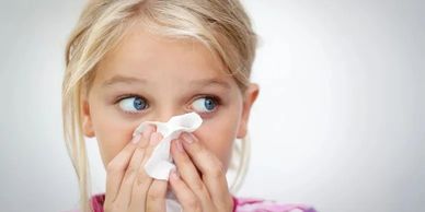 Picture of a young girl blowing her nose