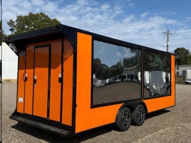 A bright orange enclosed trailer with reflective black panels and double axles.